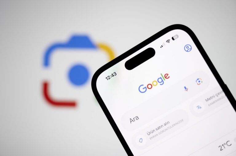 In this photo illustration a mobile phone screen displays Google homepage with the Google Lens logo in back of it.
